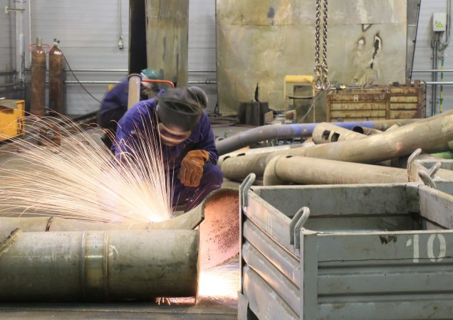 Darbuotojas Ignalinos atominėje elektrinėje pjauna metalinį vamzdį suvirinimo įranga.