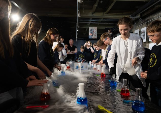 Moksleiviai dalyvauja Ignalinos atominės elektrinės organizuotame edukaciniame chemijos eksperimente.