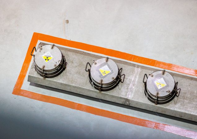 Trijų radioaktyviųjų atliekų saugojimo konteinerių dangčiai Ignalinos atominėje elektrinėje pažymėti įspėjamaisiais ženklais.