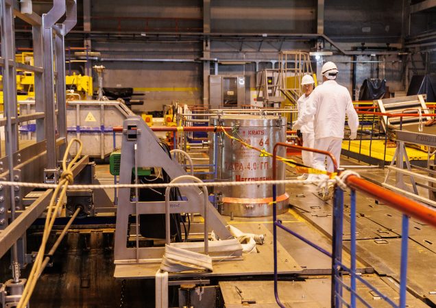 Ignalinos atominės elektrinės darbuotojai apsauginiuose drabužiuose dirba su radioaktyviųjų atliekų konteineriais reaktoriaus zonoje.