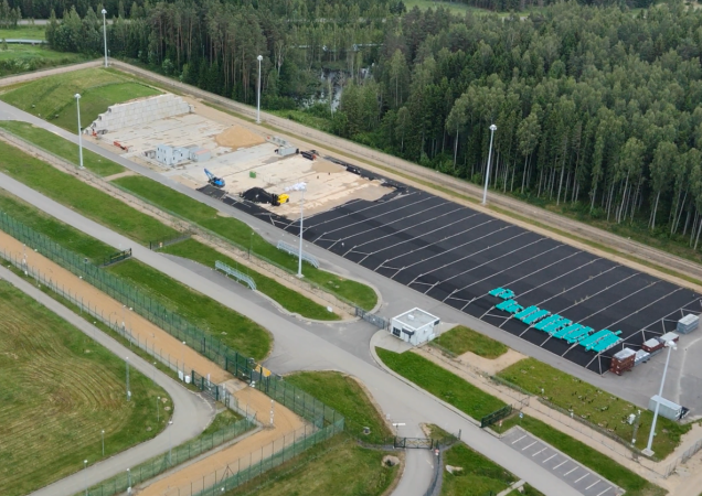 Aeronuotrauka, vaizduojanti mažo ir vidutinio radioaktyvumo atliekų paviršinį atliekyną šalia miško su įrengtomis saugojimo aikštelėmis ir apsaugine tvora.
