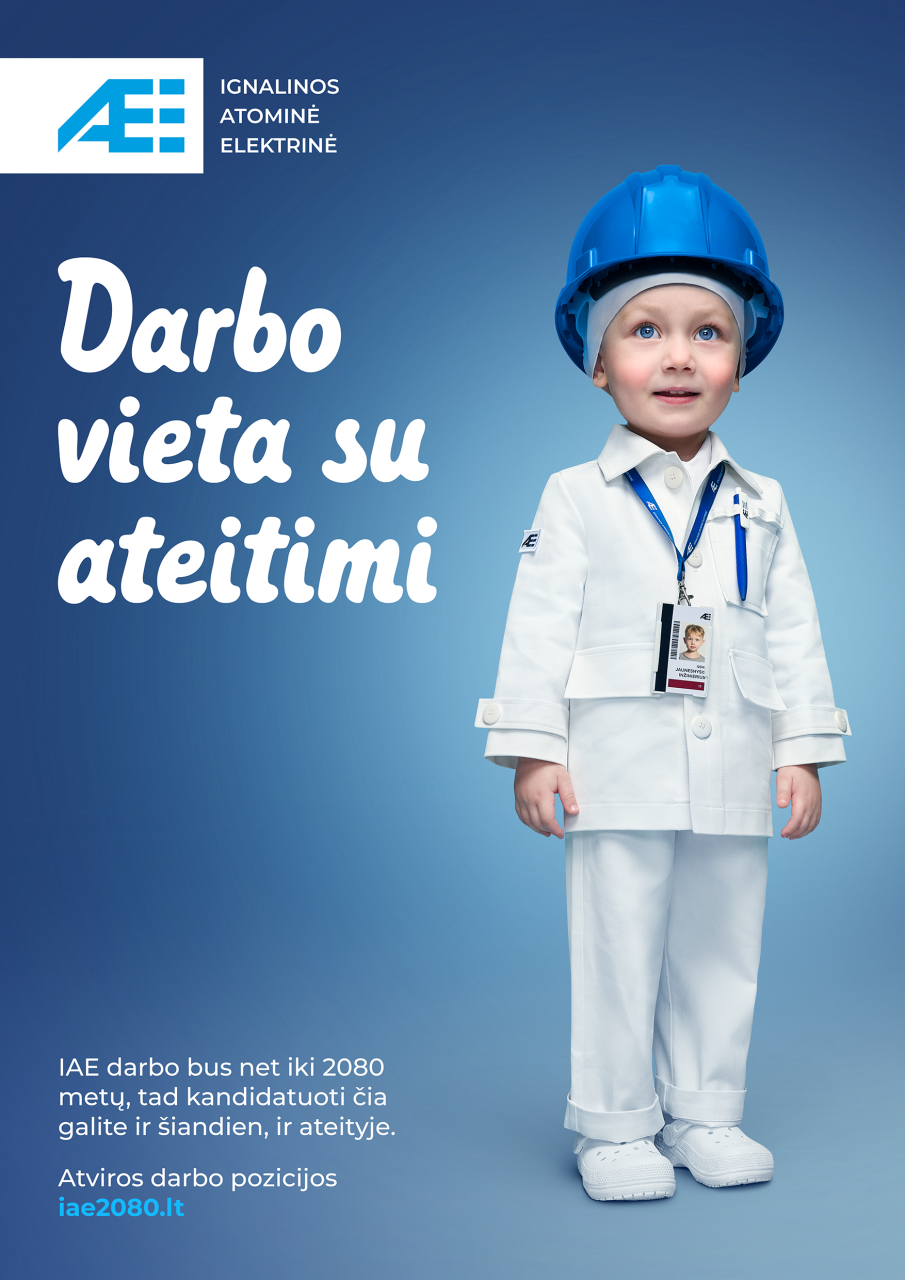 Mažas vaikas apsirengęs kaip Ignalinos atominės elektrinės darbuotojas, dėvintis šalmą ir darbo rūbus, reklamoje su šūkiu „Darbo vieta su ateitimi“.