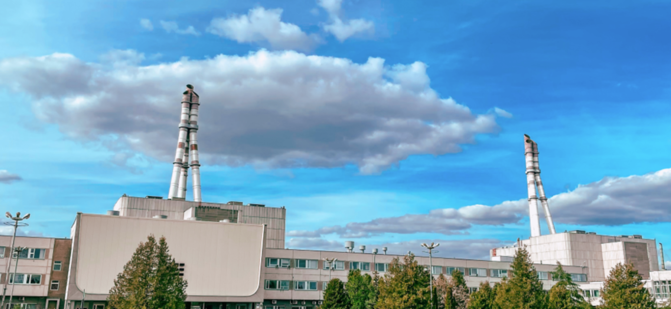 Ignalinos atominė elektrinė – du reaktoriai ir administracinis pastatas saulėtą dieną.