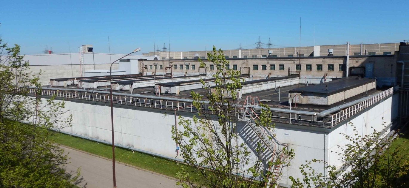 Ignalinos atominės elektrinės bitumuotų atliekų saugyklos pastatas su modernizuotomis konstrukcijomis ir turėklais ant stogo.