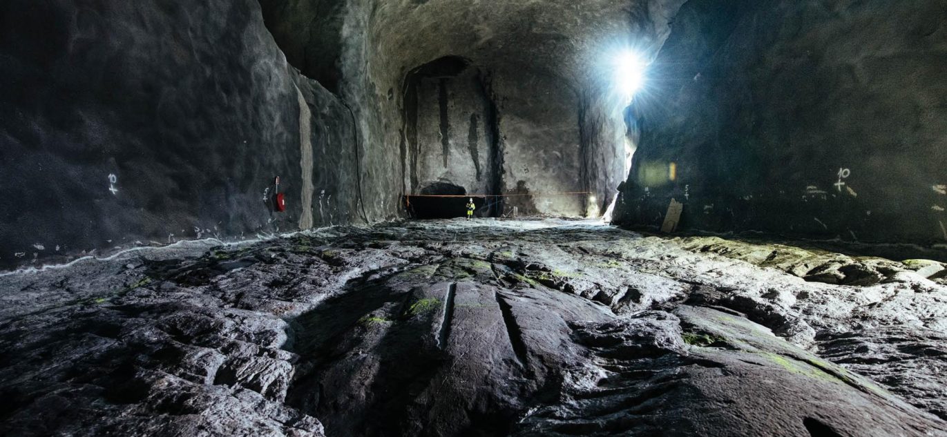 Giluminio geologinio radioaktyviųjų atliekų atliekyno požeminė kamera, esanti granito uolienose Suomijoje, su „Posiva“ logotipu dešinėje apačioje.