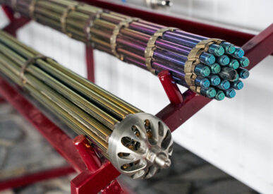 Metalinės kuro kasetės branduolinės elektrinės ekspozicijoje, žvilgančios įvairiomis spalvomis.