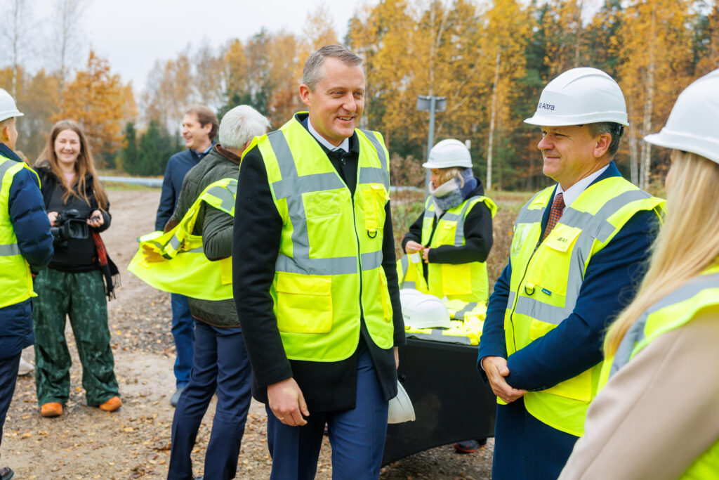 Atliekyno kapsulės įkasimo renginys, matomi įvairių organizacijų atstovai atliekyno statybvietėje