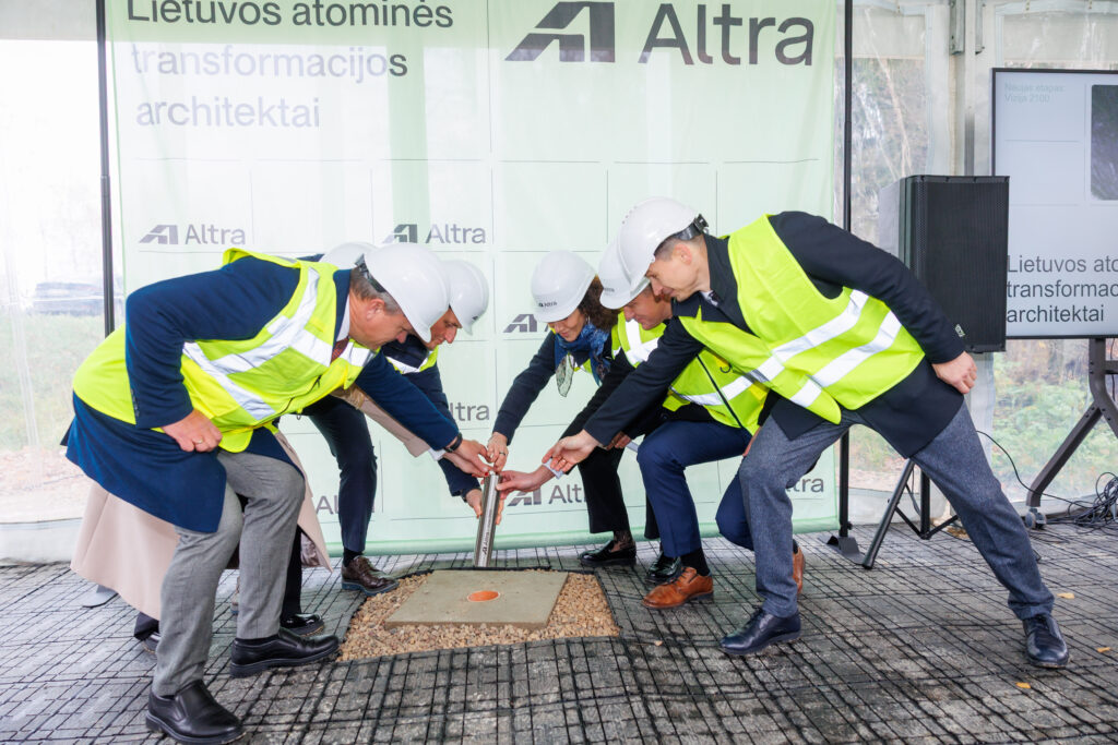 Atliekyno kapsulės įkasimo renginys, matomi įvairių organizacijų atstovai, užkasantys kapsulę