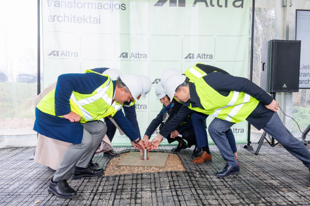 Atliekyno kapsulės įkasimo renginys, matomi įvairių organizacijų atstovai, užkasantys kapsulę