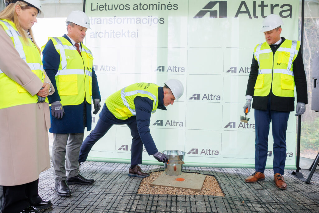 Atliekyno kapsulės įkasimo renginys, matomi įvairių organizacijų atstovai, užkasantys kapsulę