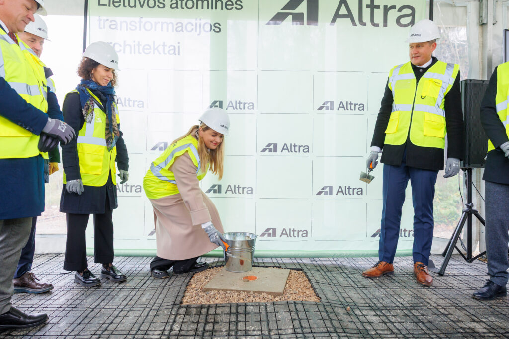 Atliekyno kapsulės įkasimo renginys, matomi įvairių organizacijų atstovai, užkasantys kapsulę