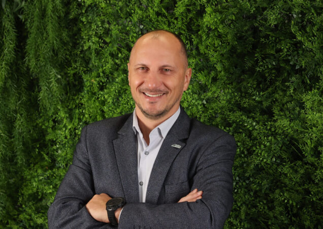 Marius Pernavas stovi prie žalios spalvos sienelės
