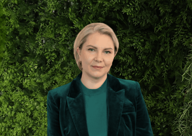 Redvita Četkauskienė stovi prie žalios spalvos sienelės