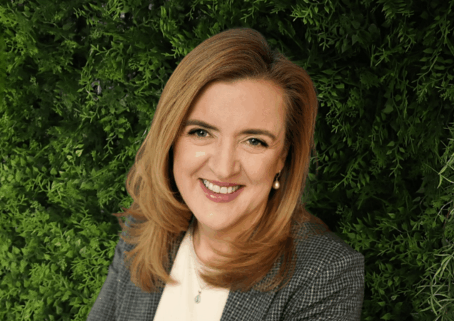 Laura Garbenčiūtė-Bakienė stovi prie žalios spalvos sienelės