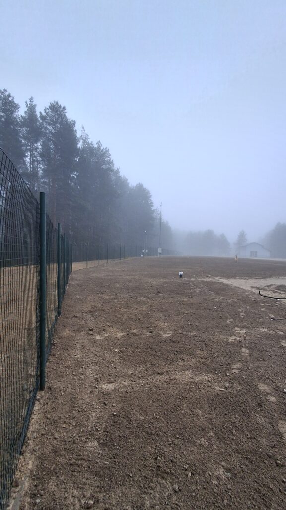 Saugyklos teritorijos vaizdas - ruda žemė, tvova, tuščia aplinka