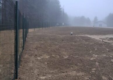 Saugyklos teritorijos vaizdas - ruda žemė, tvova, tuščia aplinka