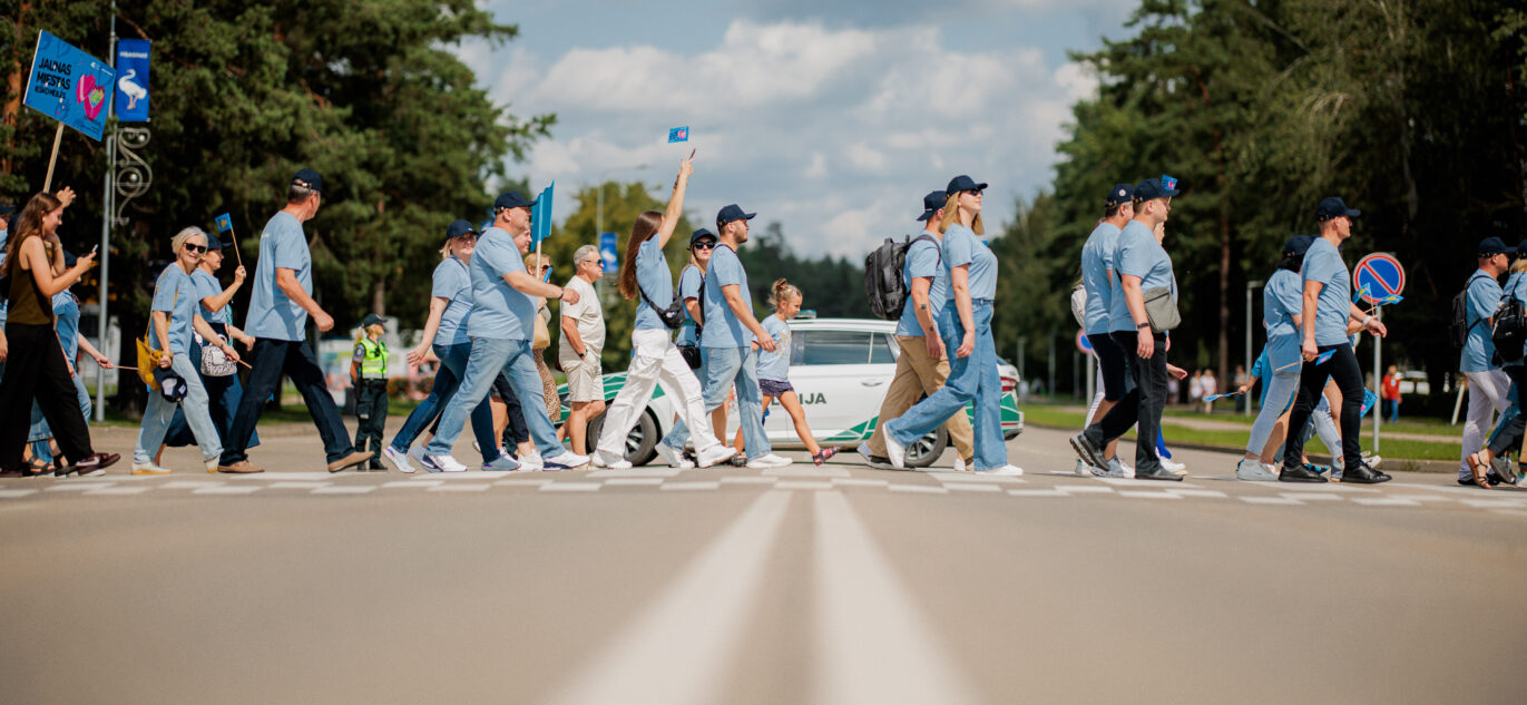 Per perėją einantys vienodais mėlynos spalvos marškinėliais apsirengę Ignalinos atominės elektirnės darbuotojai