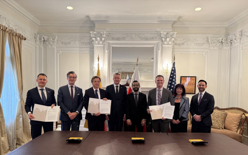 Participants of the memorandum signing ceremony present the signed documents after the official signing.
