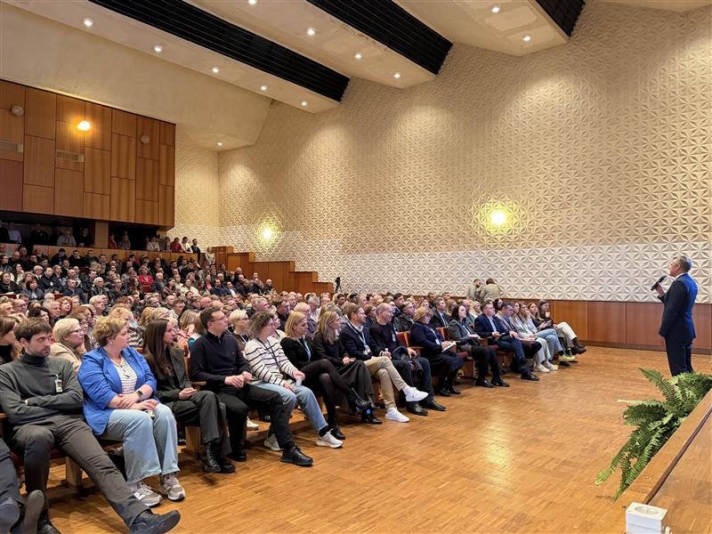 Renginio salė su žmonėmis ir pranešėju