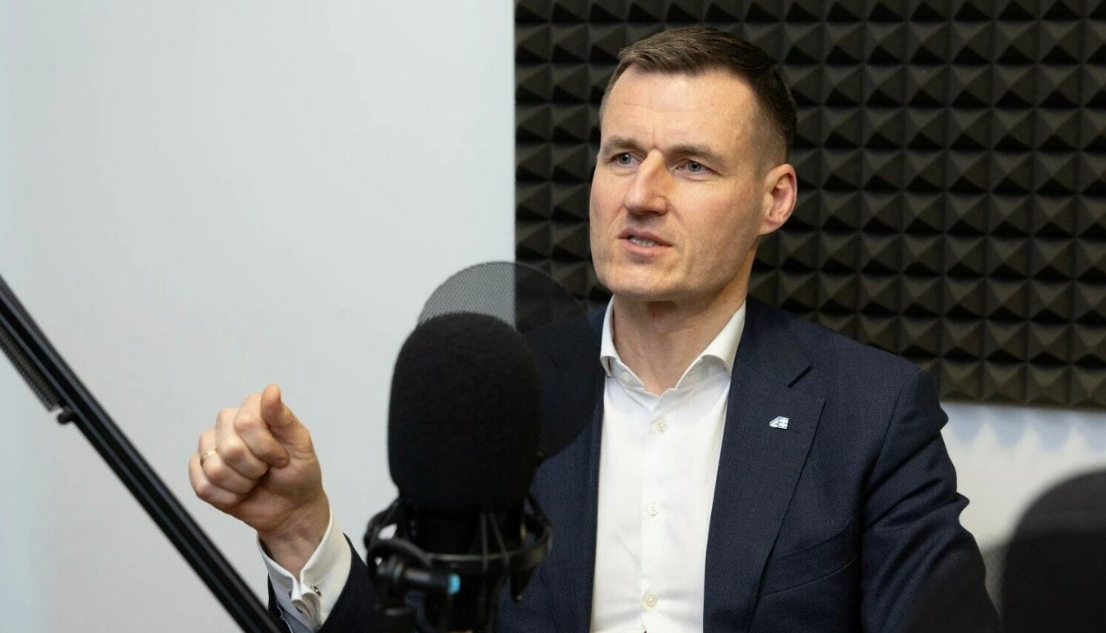 „Altra“ vadovas Linas Baužys tinklalaidės studijoje, sėdi prie mikrofono priešais garsą sugeriančią sieną