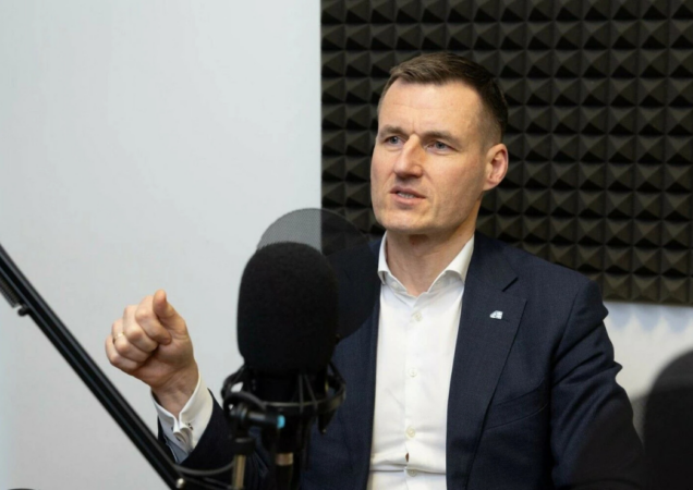 „Altra“ vadovas Linas Baužys tinklalaidės studijoje, sėdi prie mikrofono priešais garsą sugeriančią sieną