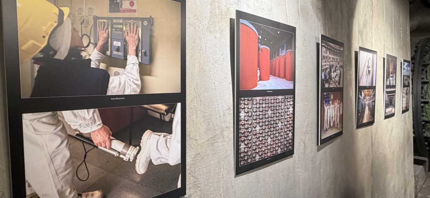 Parodos „Atominis epilogas“ fotografijos eksponuojamos ant betoninės sienos – jose vaizduojami Ignalinos atominės elektrinės darbuotojai, įranga ir skirtingos elektrinės erdvės.