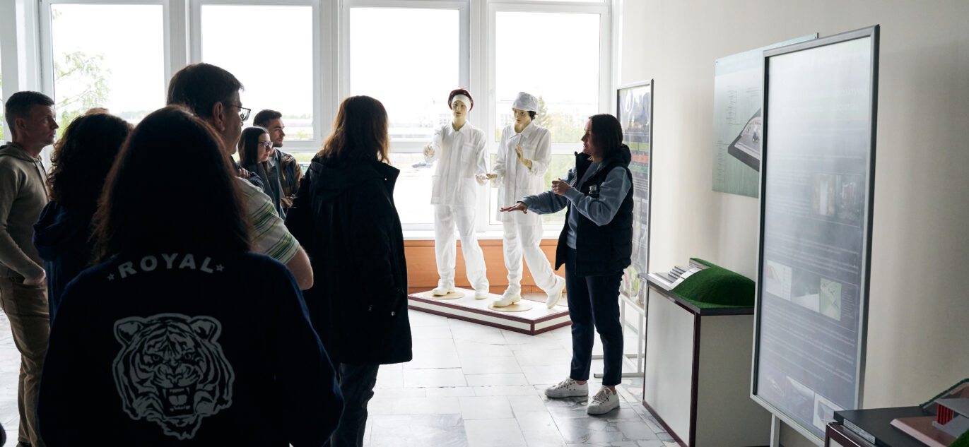 Ekskursijos dalyviai „Altra“ informacijos centro ekspozicijoje klausosi gidės pasakojimo apie atominės elektrinės istoriją ir išmontavimo projektus.
