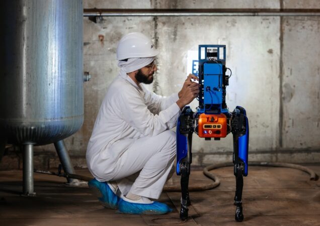 žmogus su balta apranga taiso robotą šunį